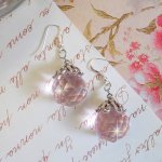 BO Rose Irisé avec des pendentifs ronds facettés en verre de bohème de couleur Rose et des coupelles Argentées. Le tout est monté avec des crochets en Argent 925/1000 pour un style romantique